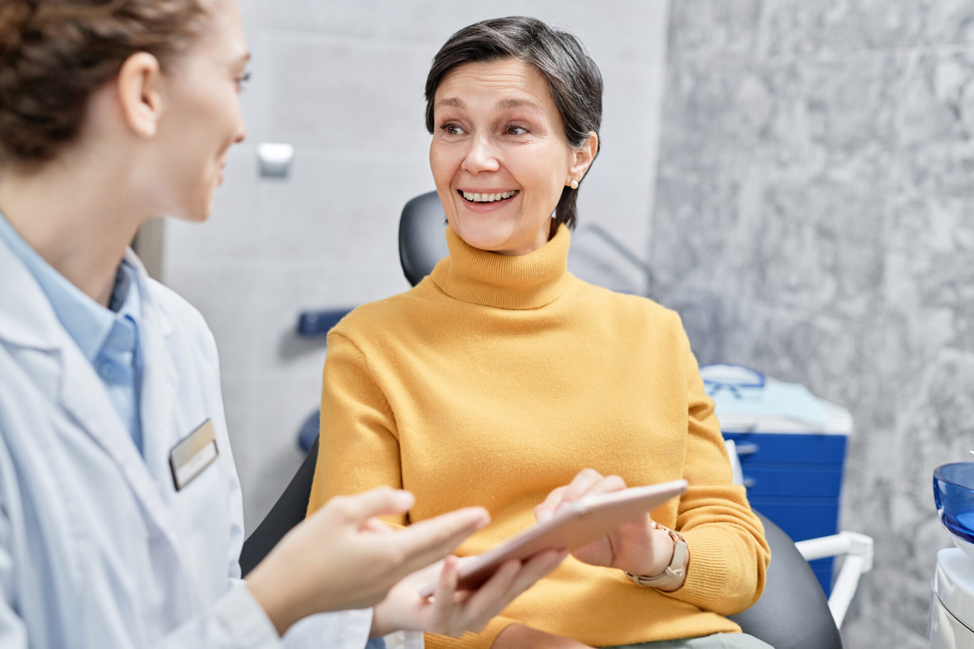 smiling mature woman in dental clinic talking to f 2023 06 16 00 09 29 utc scaled